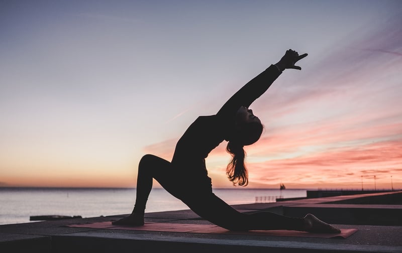Woman practicing yoga and meditation at sunrise